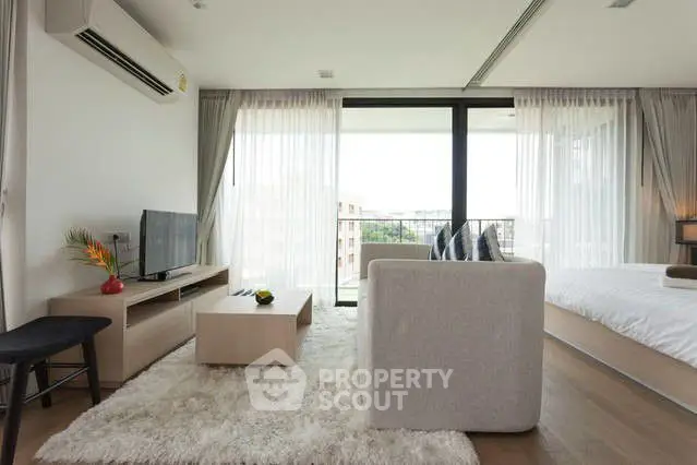 Modern living room with sleek furniture and large windows offering natural light.