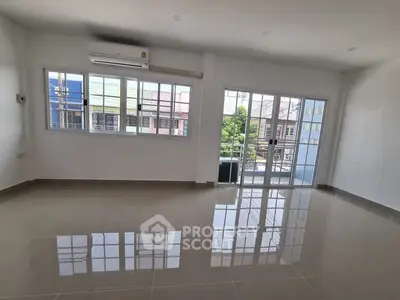 Spacious empty living room with large windows and balcony access