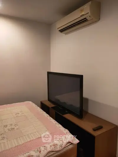 Cozy bedroom with air conditioning and TV setup for comfort and relaxation.