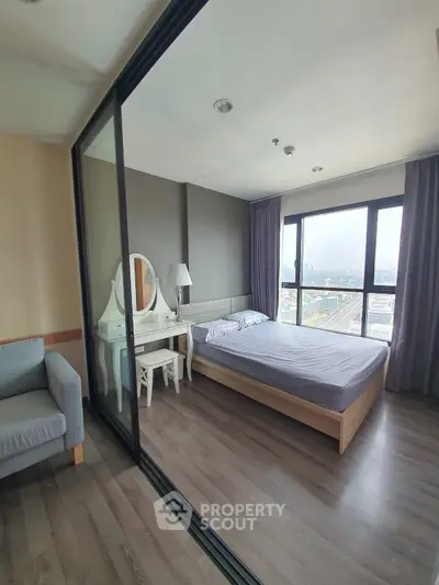 Modern bedroom with city view, featuring a cozy bed and elegant vanity set.
