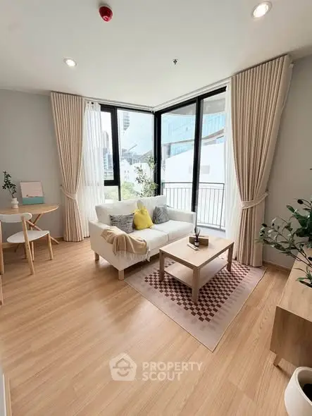 Bright and modern living room with large windows and stylish decor in a high-rise apartment.