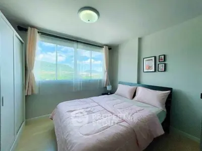 Cozy bedroom with scenic window view and soft pink bedding