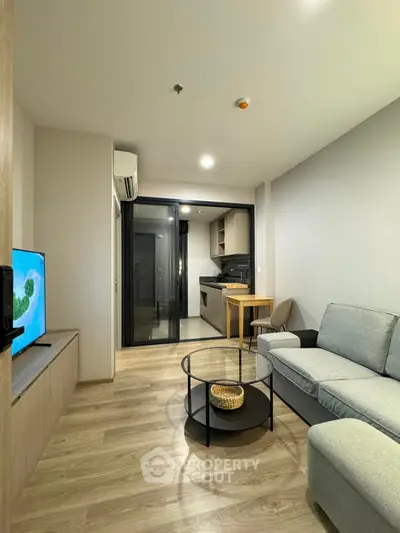 Modern living room with open kitchen, sleek furniture, and cozy ambiance