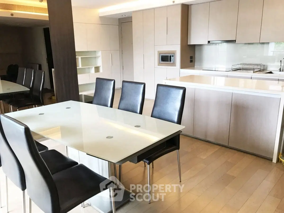 Modern kitchen with sleek dining area and built-in appliances in a stylish apartment.