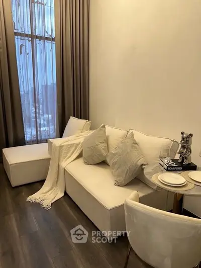 Stylish modern living room with elegant decor and floor-to-ceiling window.