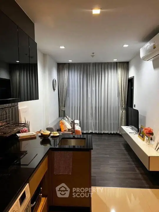 Modern living room with sleek design and open kitchen layout, featuring stylish decor and cozy ambiance.