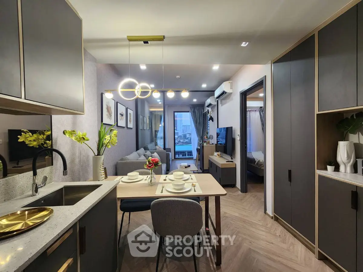 Modern open-plan kitchen and living room with stylish decor and elegant lighting.