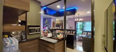 Modern open-layout kitchen with sleek appliances and view into cozy living room.