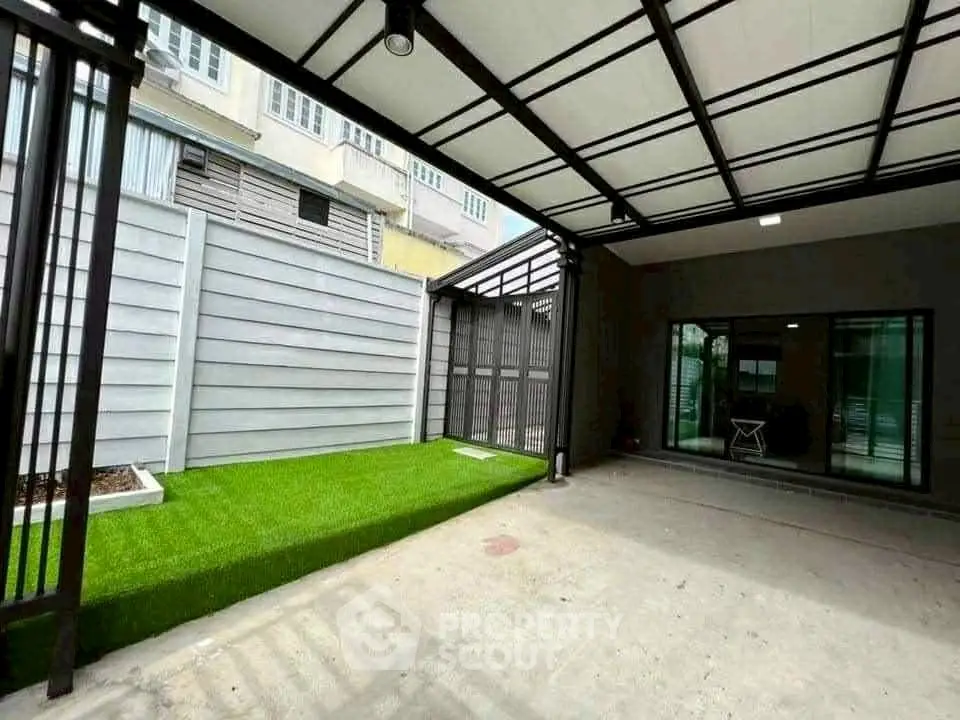 Spacious covered parking area with artificial grass and modern design.