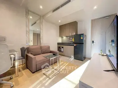 Modern living room with sleek furniture and compact kitchen in a stylish apartment.