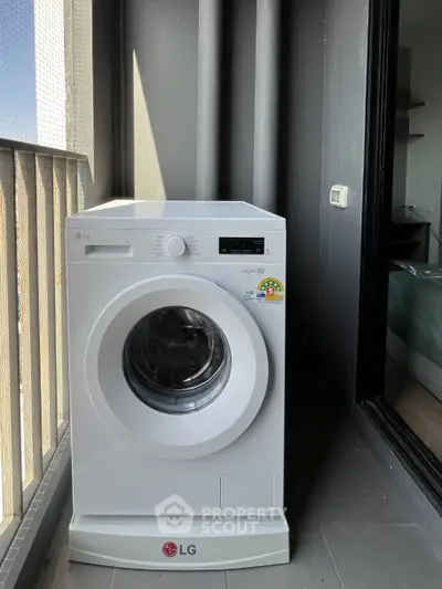 Modern washing machine on a balcony with sleek design and urban view.