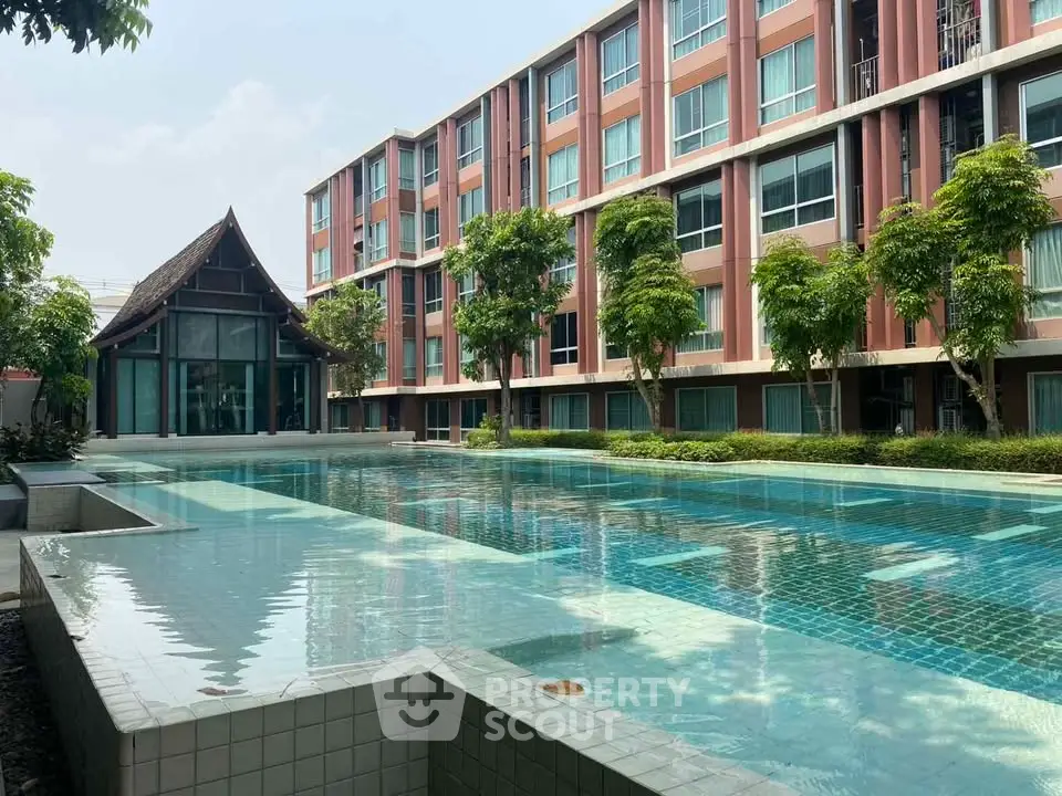 Luxurious apartment complex with stunning pool and lush greenery