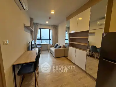 Modern living room with stylish furniture and large window offering city views