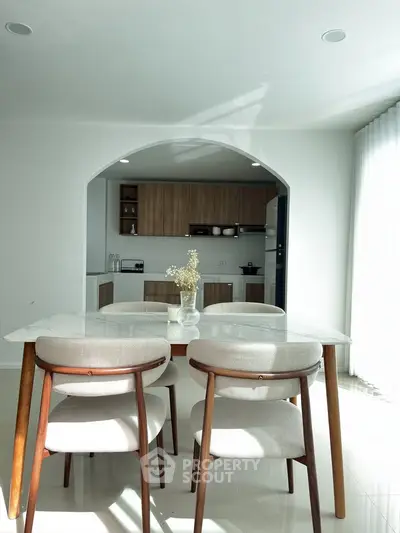 Modern dining area with elegant chairs and open kitchen layout