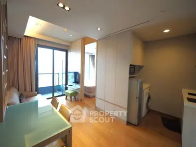 Modern apartment interior with open layout, featuring a cozy living area, dining space, and balcony access.