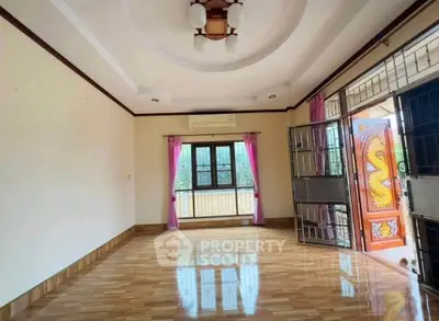 Spacious living room with wooden flooring and decorative door