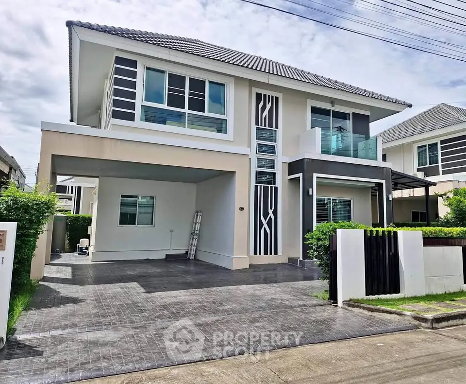 Modern two-story house with sleek design and spacious driveway in a suburban neighborhood.