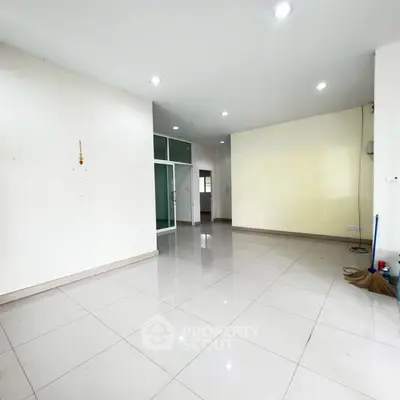 Spacious empty room with tiled flooring and bright lighting