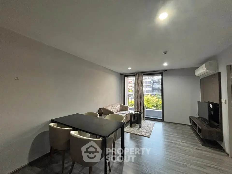 Modern living room with sleek furniture and balcony view in urban apartment