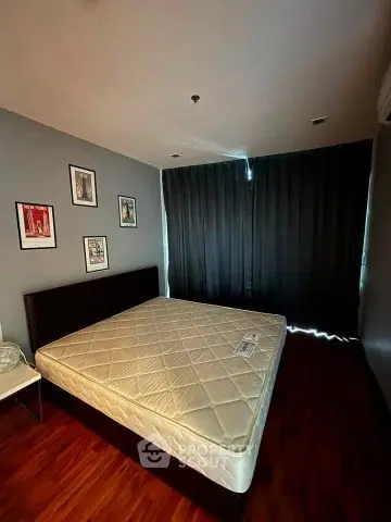 Spacious bedroom with modern decor and large window for natural light.