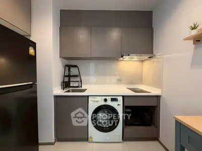 Modern kitchen with sleek cabinetry, built-in washing machine, and contemporary appliances.