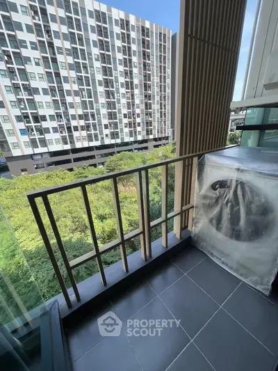 Modern balcony with scenic view of greenery and contemporary building facade.
