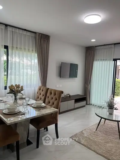 Elegant dining and living area with modern decor and natural light