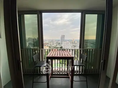 Stunning city view from a modern balcony with seating area, perfect for relaxation.