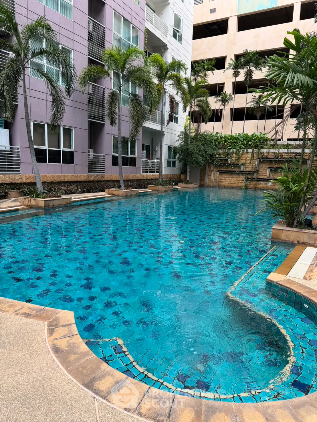 Luxurious residential pool area with palm trees and modern architecture, perfect for relaxation and leisure.