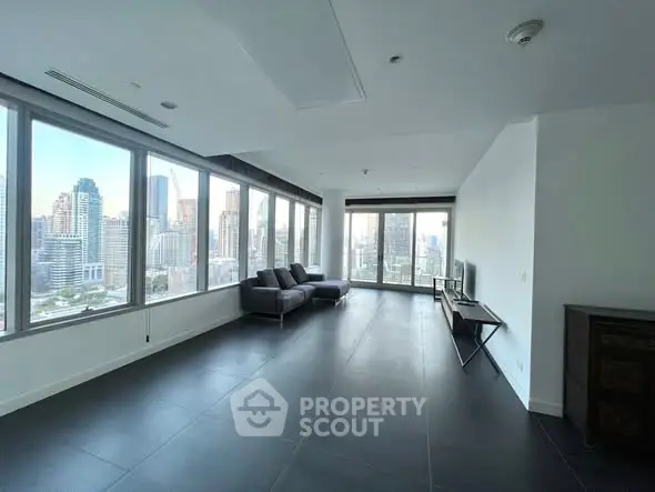 Spacious modern living room with panoramic city views and sleek furnishings.