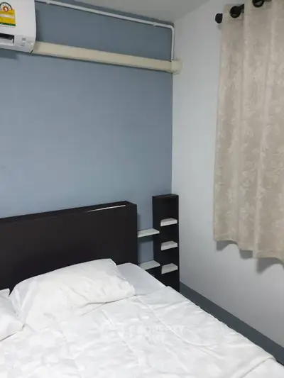 Cozy bedroom with minimalist design and soft blue accent wall.