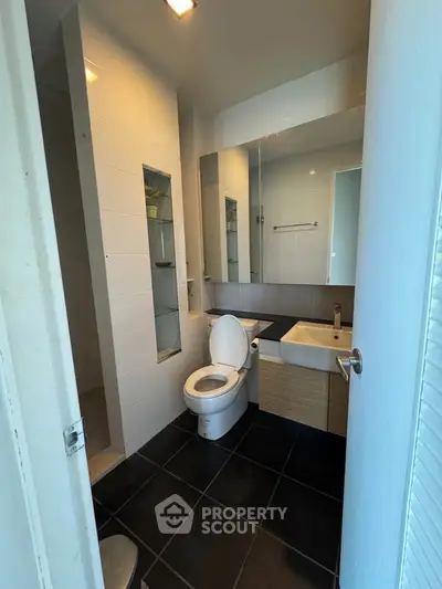 Modern bathroom with sleek fixtures and black tile flooring