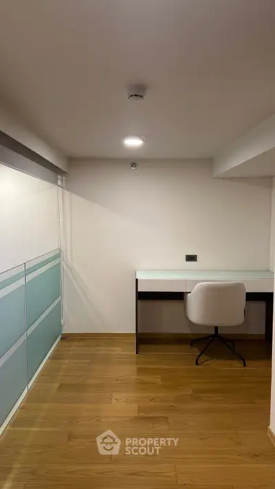 Modern study room with sleek desk and chair on wooden flooring