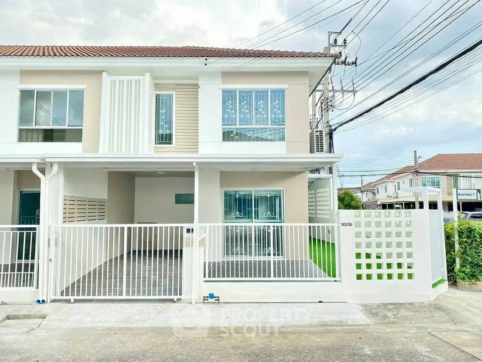 Modern two-story townhouse with gated entrance and spacious driveway in a serene neighborhood.