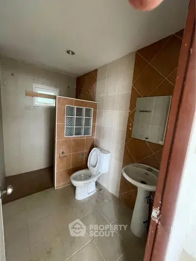 Spacious bathroom with modern fixtures and tiled walls, ideal for comfort and style.