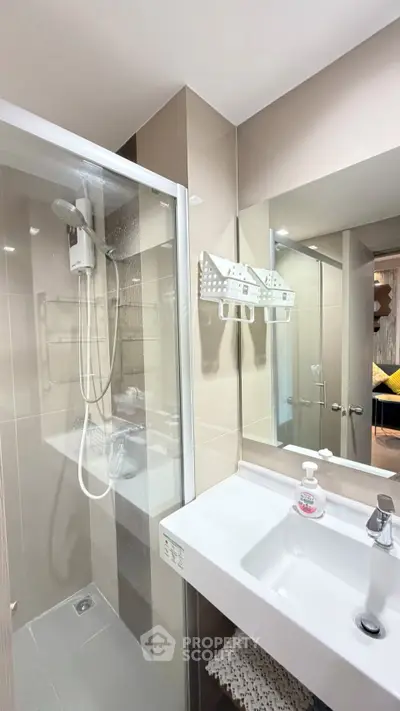 Modern bathroom with sleek shower and stylish sink in contemporary apartment.