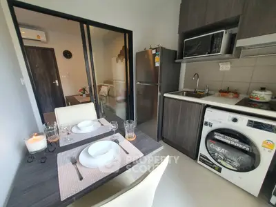 Modern kitchen with dining area and appliances in compact apartment