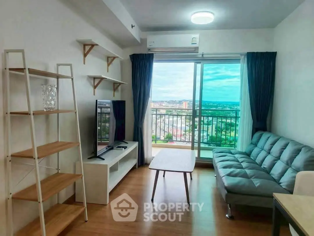 Modern living room with balcony view, featuring sleek furniture and natural light.