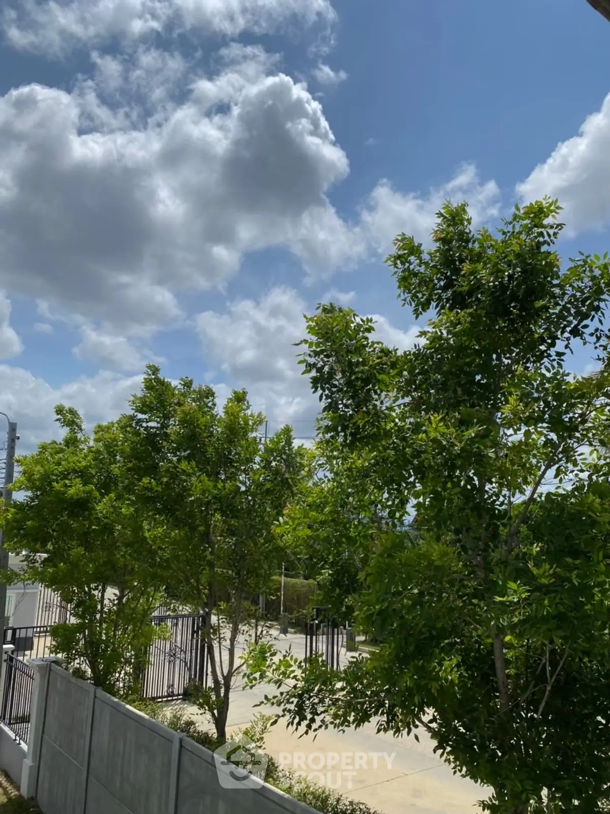Serene garden view with lush greenery and clear blue sky, perfect for tranquil living.