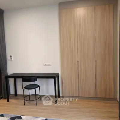 Modern bedroom with sleek wardrobe and minimalist desk setup