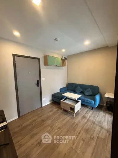 Cozy living room with modern furniture and wooden flooring in a stylish apartment.