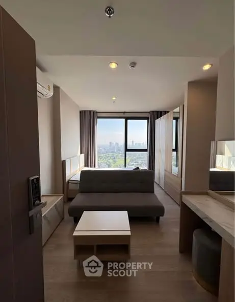 Modern living room with city view, featuring sleek furniture and natural light.