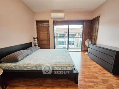 Spacious bedroom with balcony access and modern furnishings