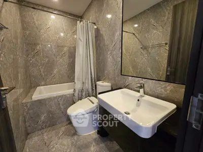 Luxurious modern bathroom with marble walls and sleek fixtures in a high-end property.
