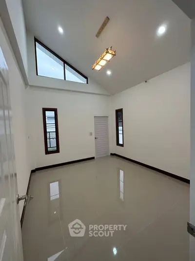 Spacious room with high ceiling and modern lighting in a contemporary home.