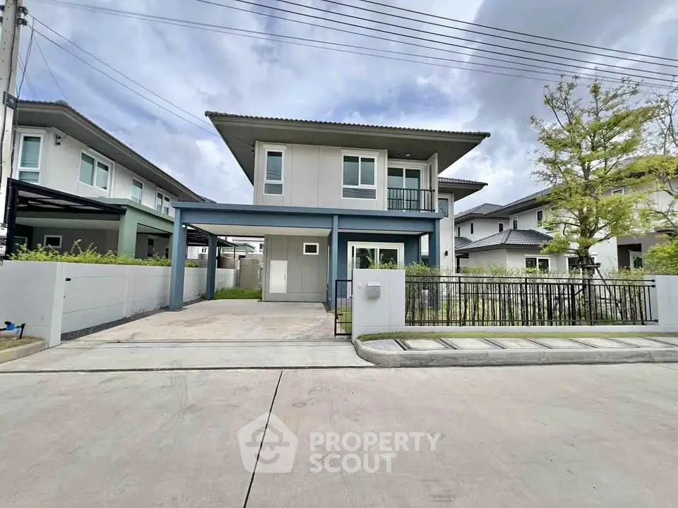 Modern two-story house with driveway and landscaped front yard in suburban neighborhood.