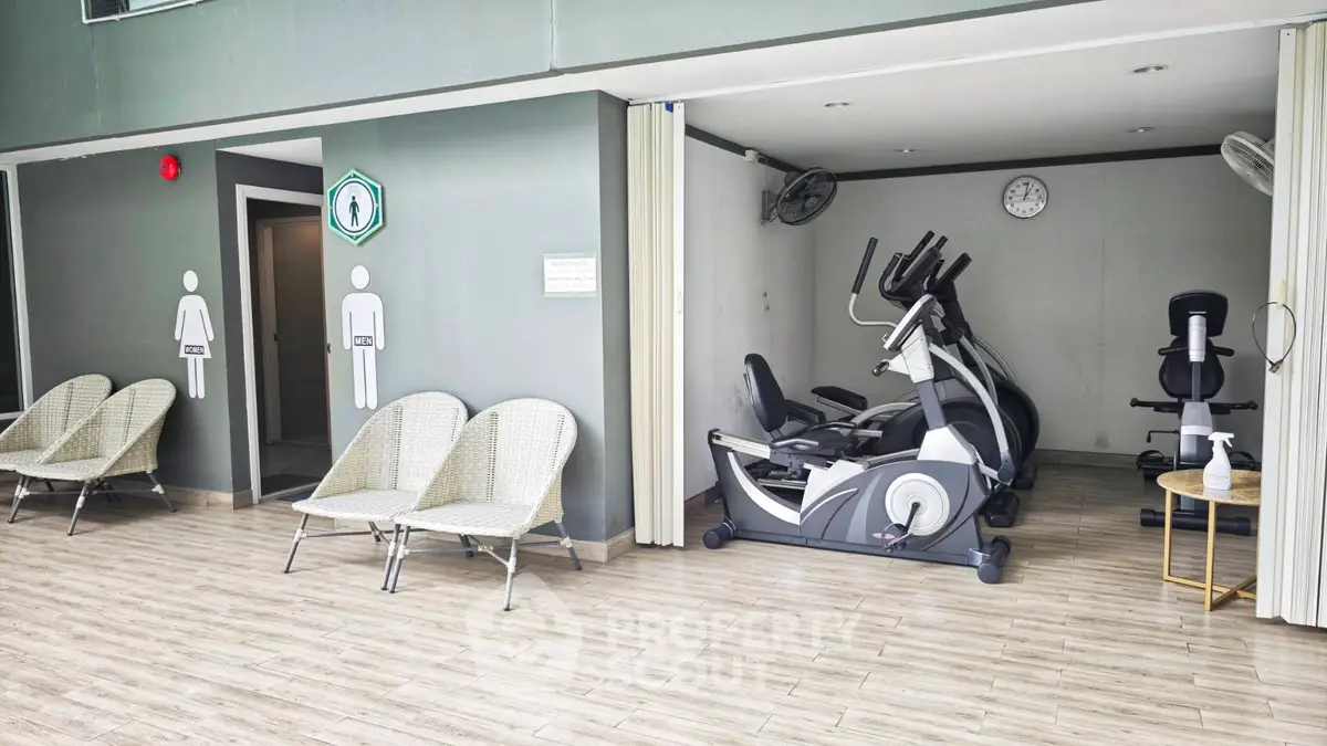Modern gym area with exercise equipment and seating in a residential building