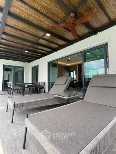 Luxurious balcony with modern lounge chairs and dining area, perfect for relaxation and entertainment.