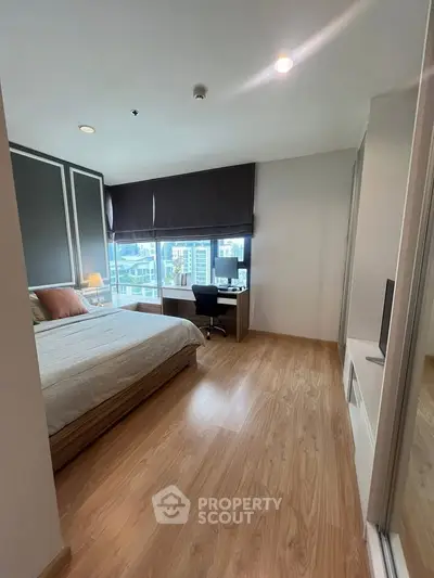 Modern bedroom with city view, wooden flooring, and stylish decor