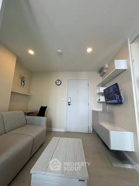 Modern living room with sleek furniture and wall-mounted TV, perfect for contemporary living.